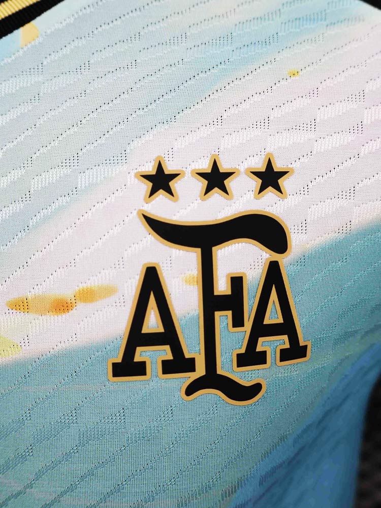 Logo AFA maillot Argentine Painting 2026 bleu et or – blason noir et doré trois étoiles