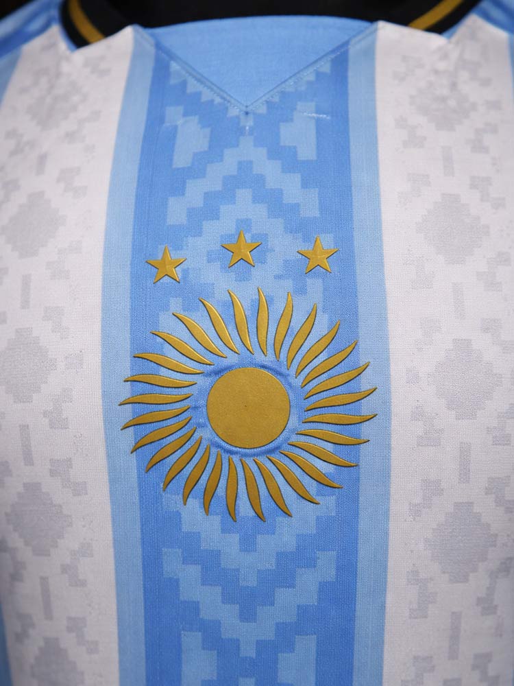 Détail soleil doré maillot Argentine Pulga blanc 2026 – emblème central avec trois étoiles