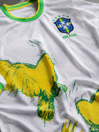 Détail de l'imprimé colombe jaune et vert sur le maillot Brésil blanc, effet peinture