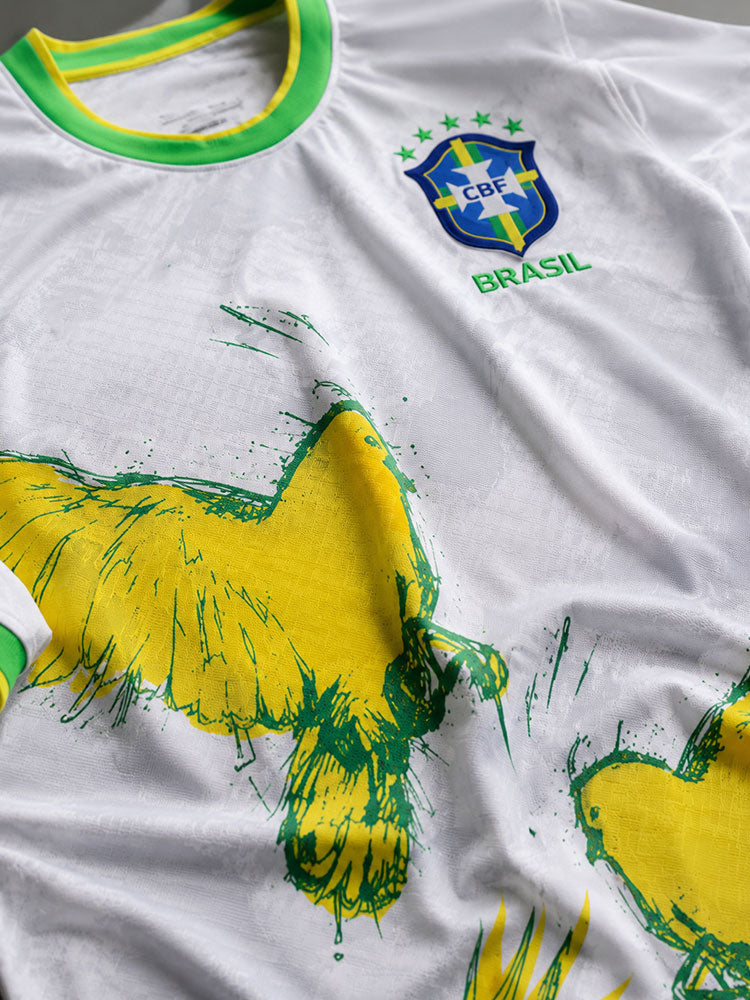 Détail de l'imprimé colombe jaune et vert sur le maillot Brésil blanc, effet peinture