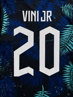 Dos du maillot Brésil bleu avec flocage « VINI JR 20 » blanc sur motif feuilles tropicales