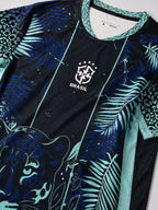 Zoom tissu du maillot Brésil bleu, motif jaguar, fougères et léopard turquoise – écusson CBF